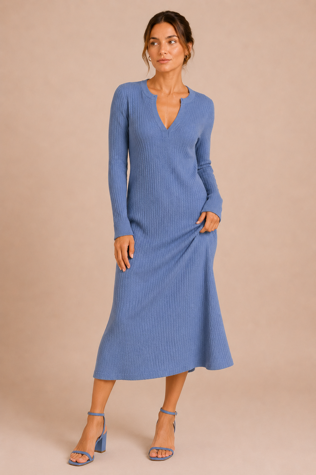 Woman wearing a blue ribbed dress against a beige background