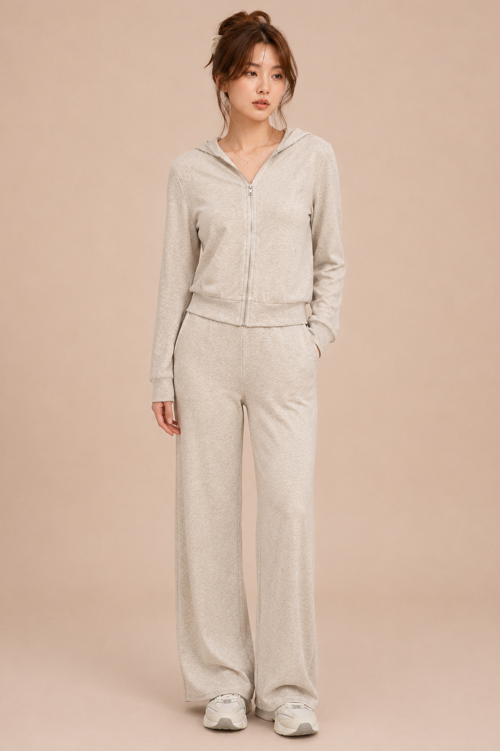 Woman wearing a beige cardigan and pants on a beige background