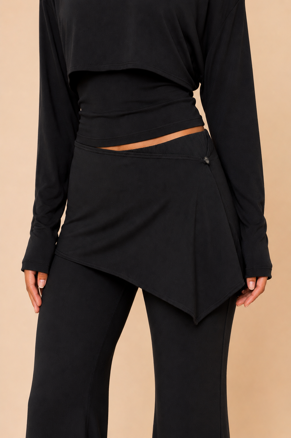 Woman wearing a black outfit with a beige background