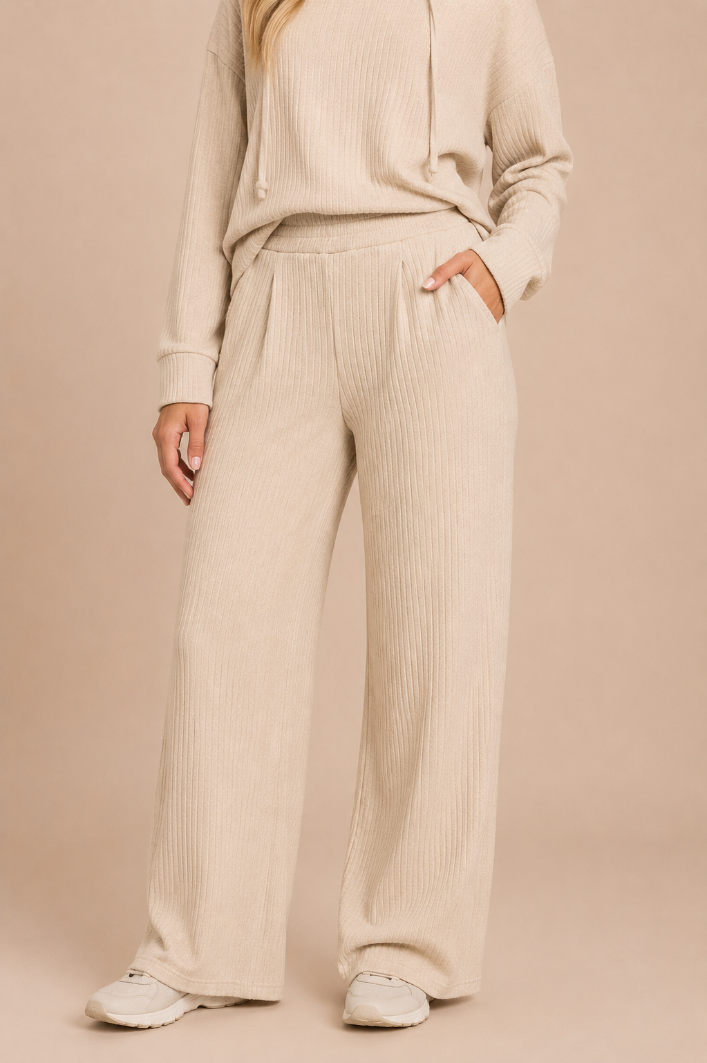 Woman wearing a beige ribbed knit outfit on a beige background