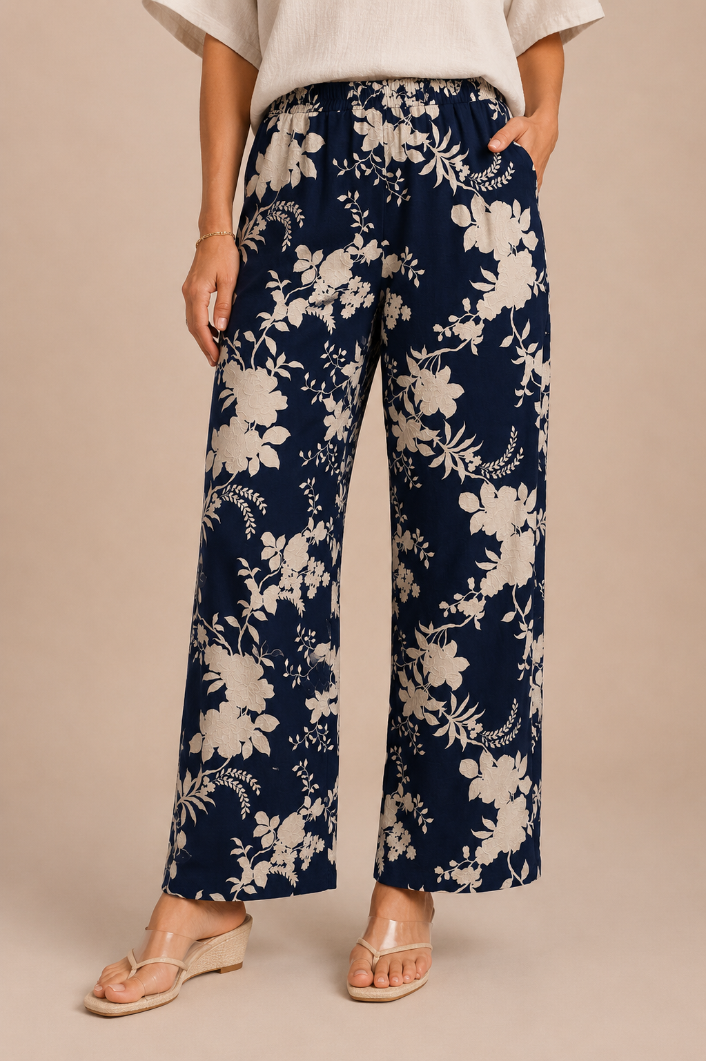Navy blue floral-patterned pants worn by a person on a beige background