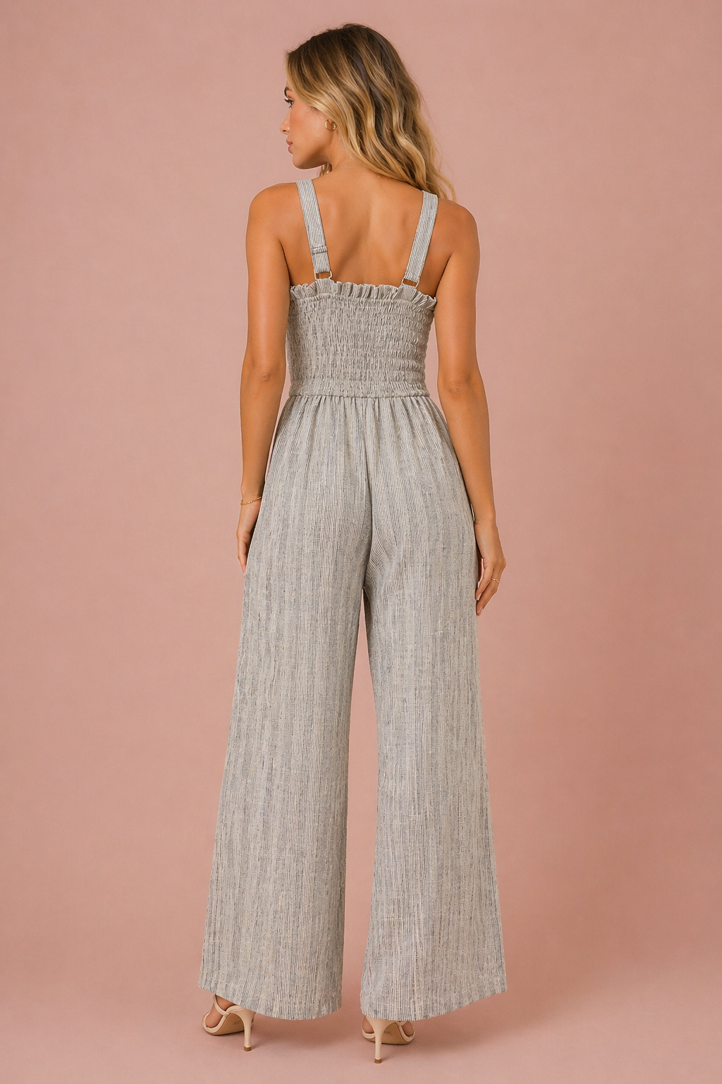 Woman wearing a striped jumpsuit on a pink background